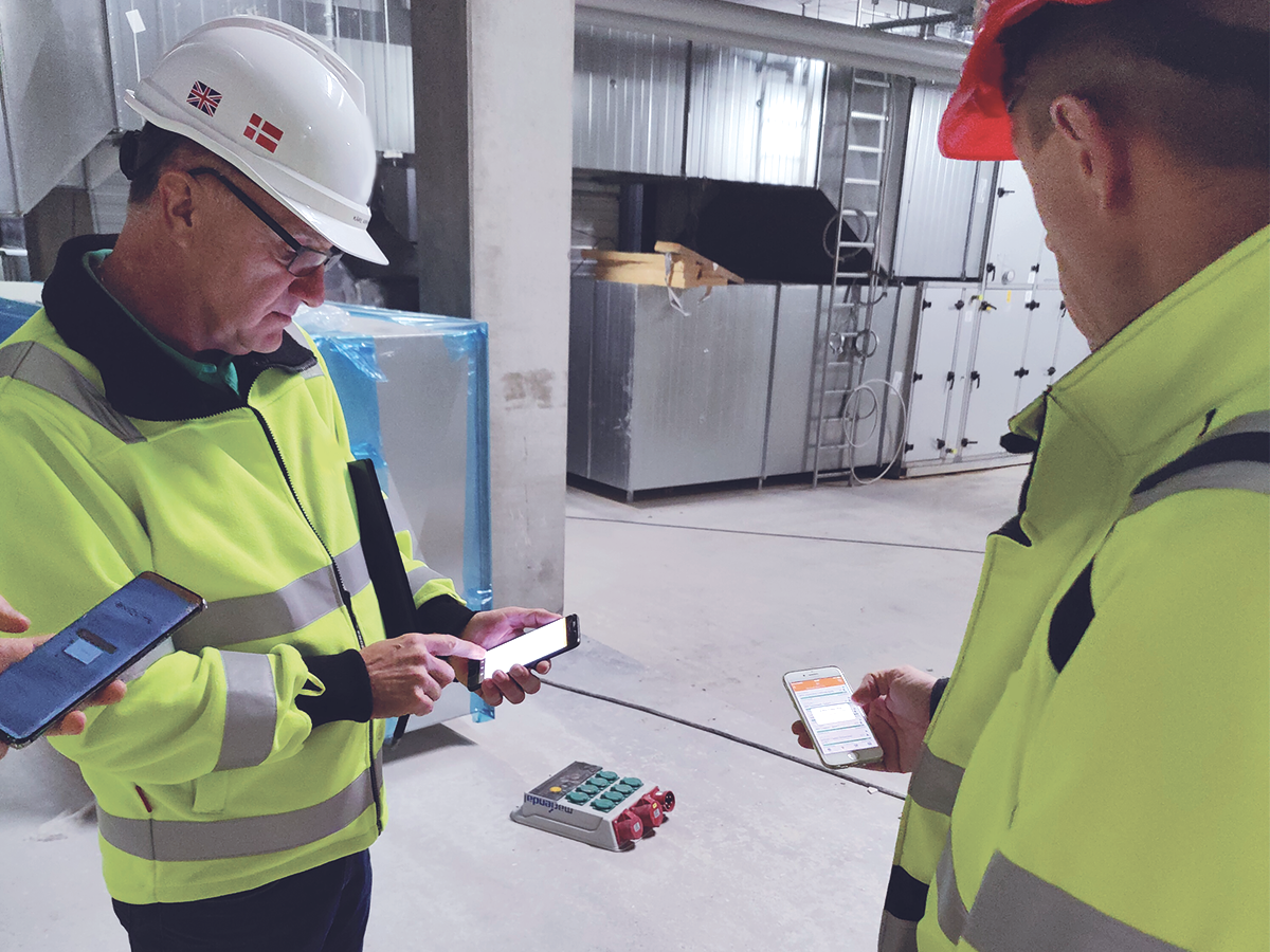 Workers on a construction site use the Exicute App