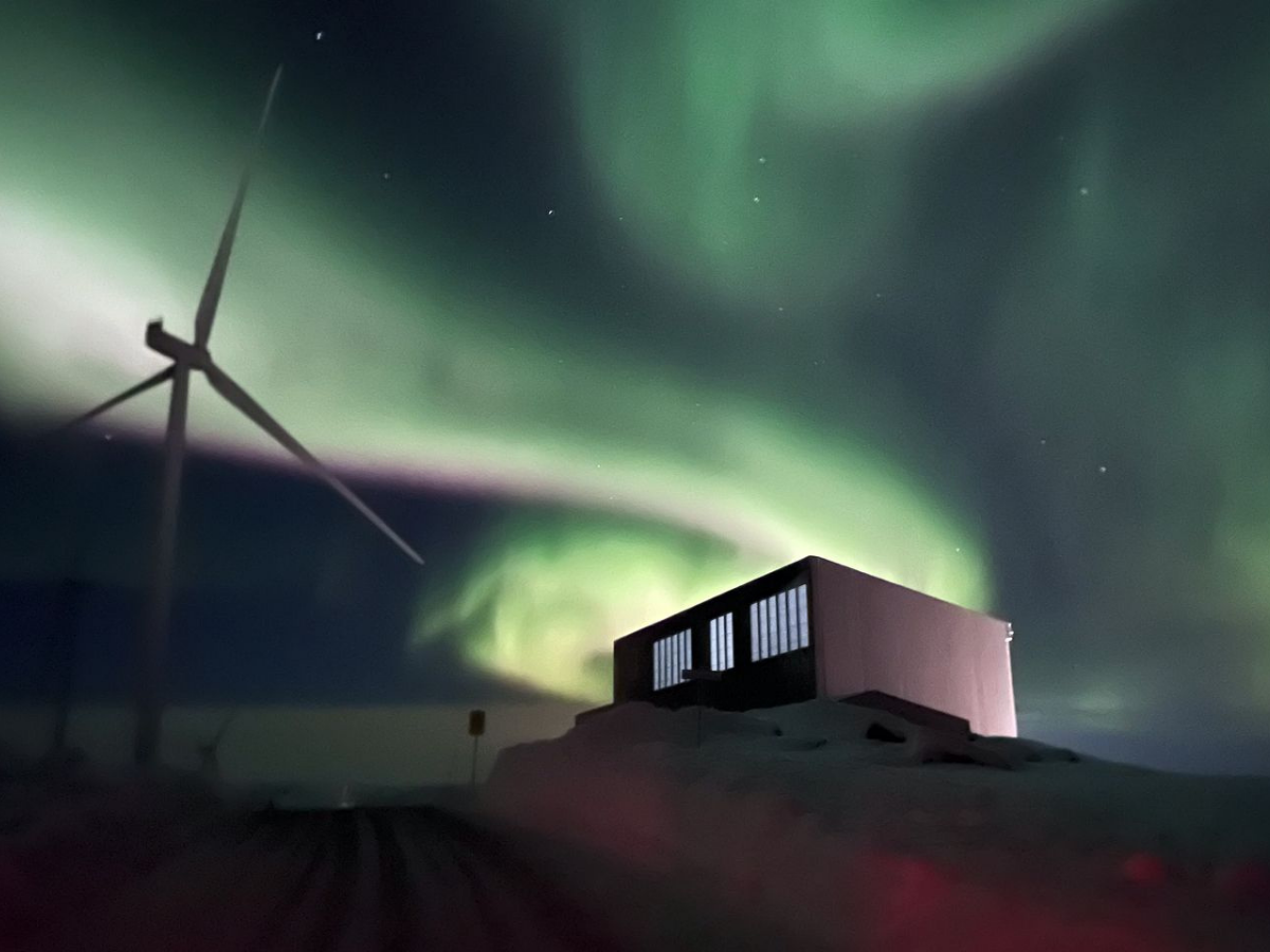 Wind turbine and building under polar lights